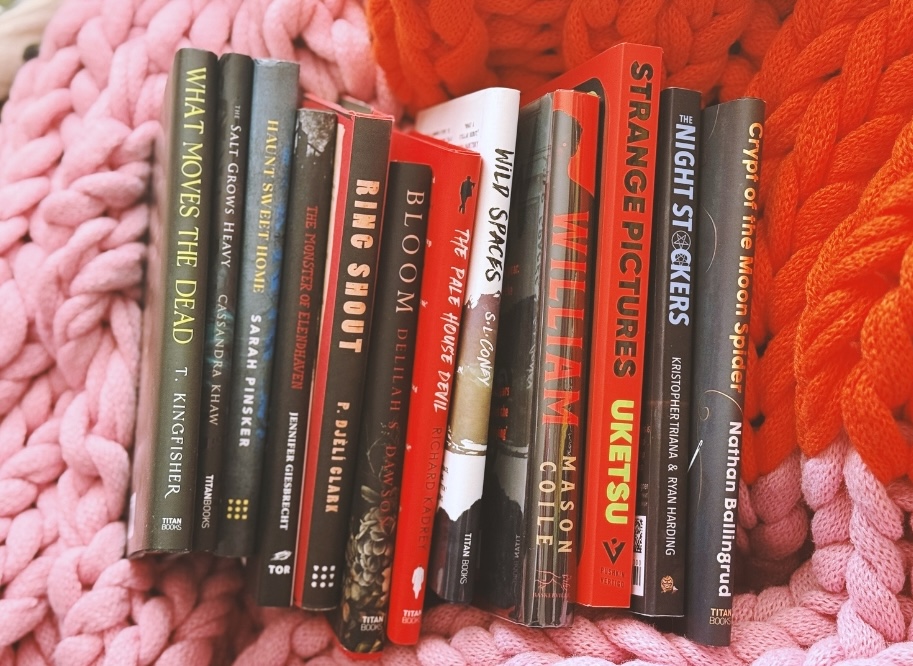 12 books on a pink and orange blanket 