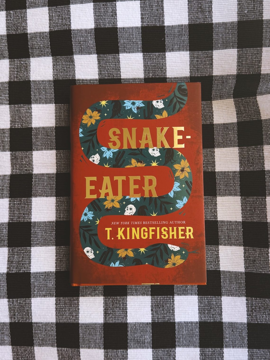 Snake Eater by T Kingfisher - Book Cover on a checkered surface
